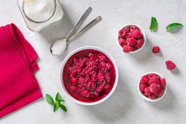 istock Raspberry jam in a bowl, fresh berries and mint leaves on a light background. Top view. Healthy breakfast idea 1408847530