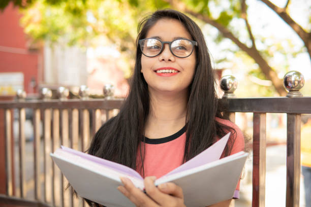 istock Happy college student holding a book and thinking about something. 1408848314