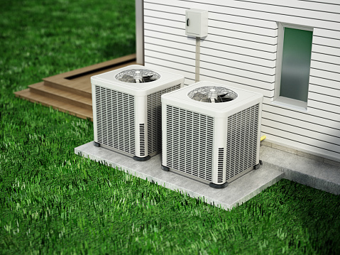 Two heat pumps standing near the house wall.
