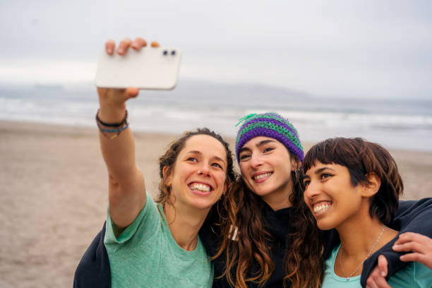 istock three smiling young women taking selfie on the beach 1408849228