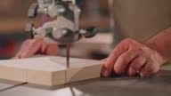 istock SLO MO Male hands cutting a piece of wood with the scroll saw 1408852275