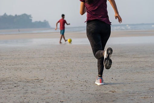 Mumbai, India - 15 August 2021, A woman running at a beach. Jogging, yoga, workout, exercise, healthy life, diet, lifestyle, sedentary, active, fit, fresh, fitness, periods, sunlight, muscle concept.