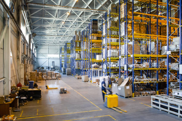 interior of a modern warehouse storage of retail shop with pallet truck near shelves - armazém de distribuição imagens e fotografias de stock