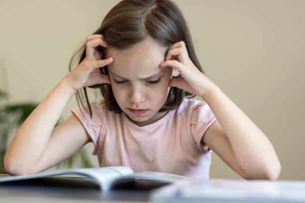 istock Tired girl reading a book at home 1408858248