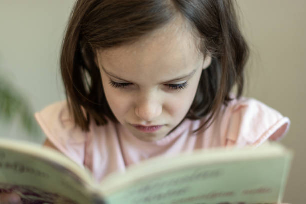 istock Tired girl reading a book at home 1408858255