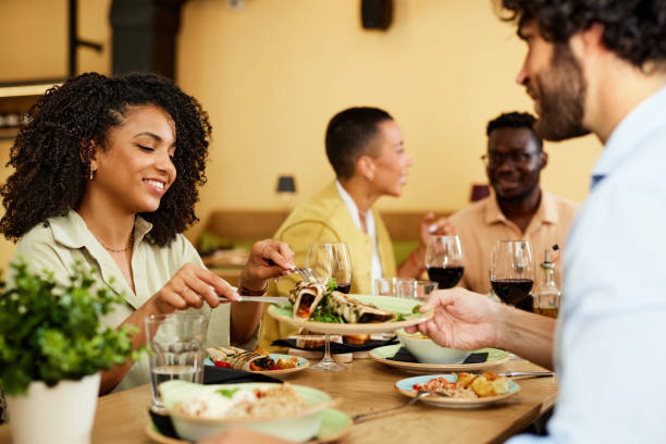 istock Friends sharing food in a restaurant while having dinner. 1408861454