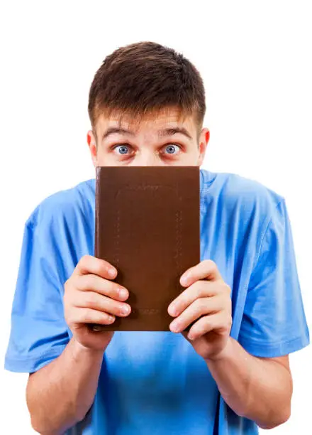 Scared Young Man behind a Book Isolated on the White Background