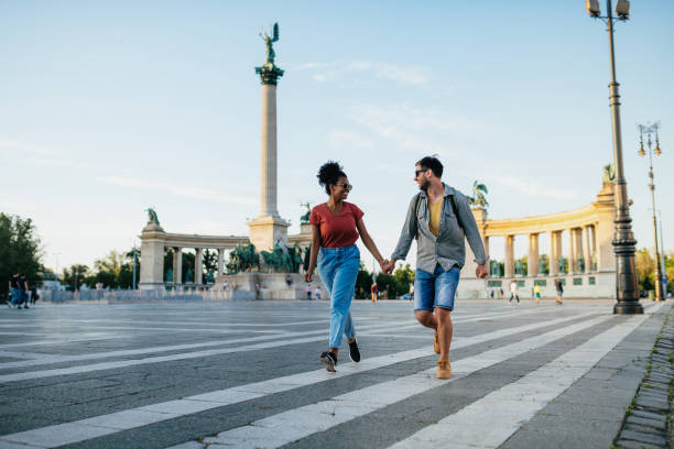 Affectionate multiracial couple dancing in the city near famous monuments stock photo