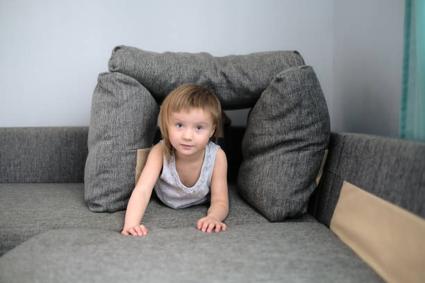 istock funny European child playing with pillows on couch 1408865892