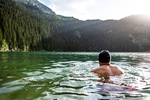 Young man relaxing after hiking and swimming in Black lake in Durmitor national park