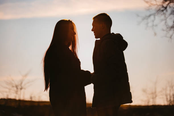 istock Young Couple Holding Hands In Silhouette 1408866983