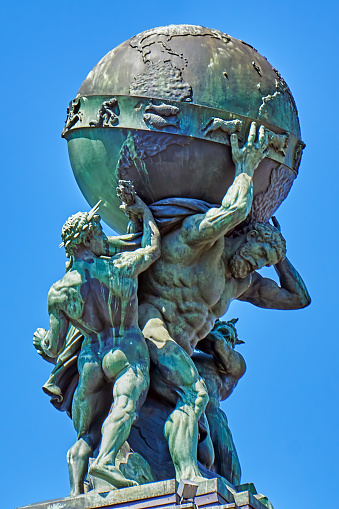 Frankfurt am Main, Germany - July 08. 2022: Group of Atlas figures on the entrance portal of Frankfurt Central Station. Atlas carrying the globe, aided by steam and electricity. Created by the sculptor Gustav Karl Martin Herold in the 19th century.