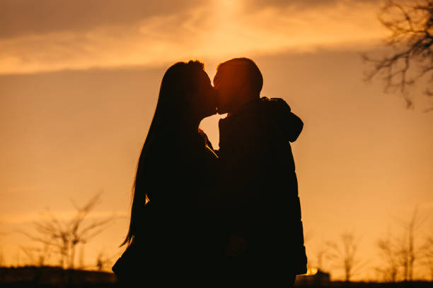 istock Young Couple Kissing In Silhouette 1408868035