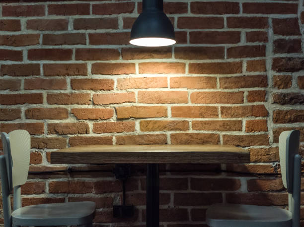 istock Lamp near a brick wall. Wooden table and chairs. Loft interior. 1408869789