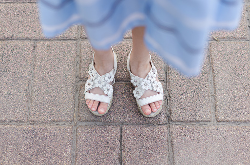 Little Girl Stand on Road with Sandals