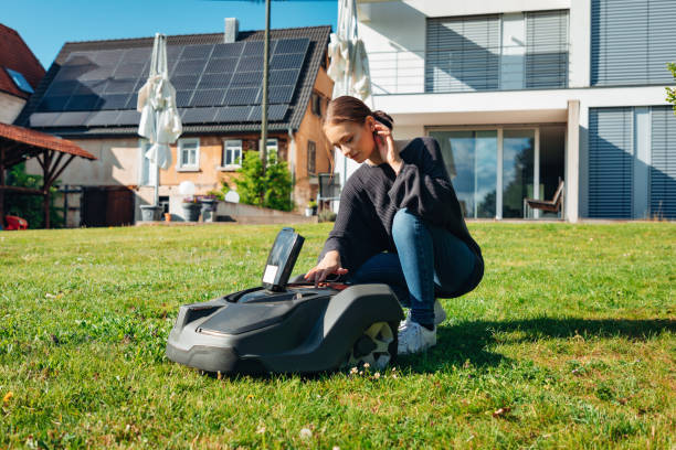 istock Woman in Home Garden programming Robotic Lawn Mower 1408875597