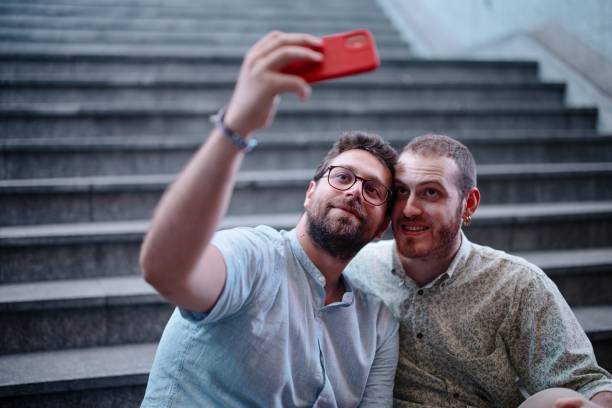 istock Loving gay couple taking selfie while on a date at night 1408875909