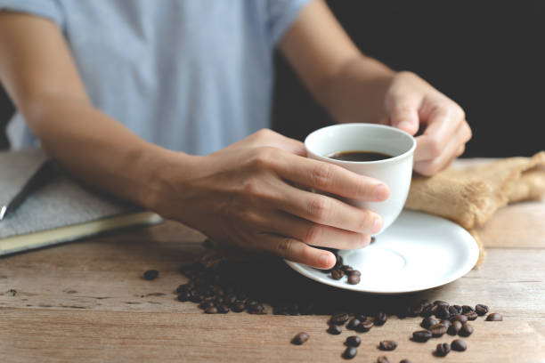 istock A cup coffee in hand ,notebook and pen on the wooden table. 1408877456