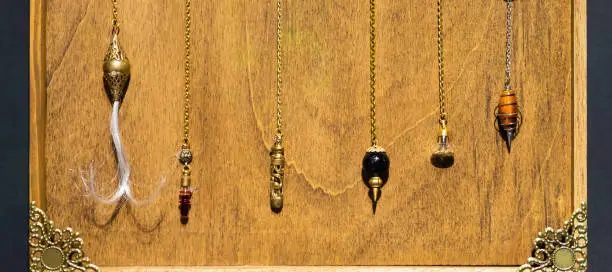 Photo of Esoteric magic pendulum. Vintage symbol of esoterism, withcraft and fortune-telling