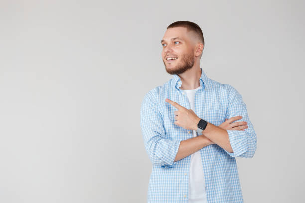 istock Young handsome bearded man pointing to the side 1408888424