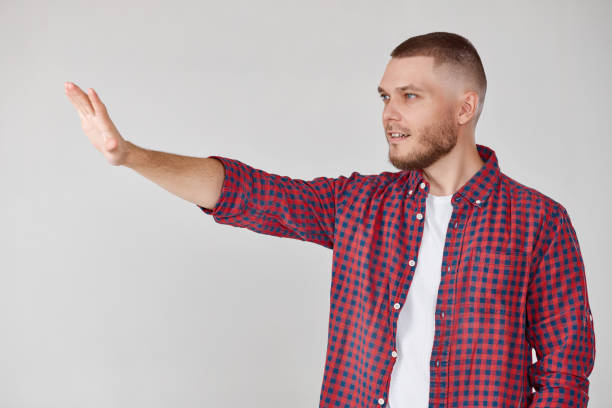 istock Young handsome bearded man pointing to the side 1408888565