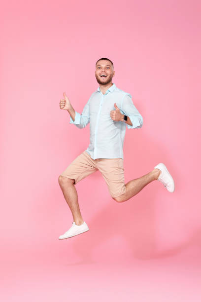 istock man in summer clothes jumping on pink background. 1408889095