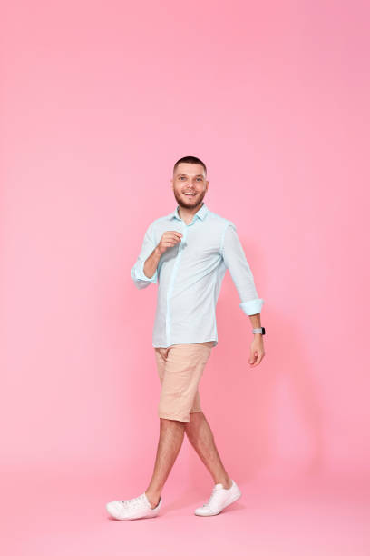 istock handsome man walks isolated on pink background 1408889119