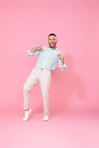 istock handsome smiling man in blue shirt dancing 1408889151