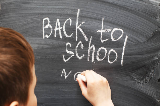 istock the child writes on a blackboard. Back to school concept background 1408889639