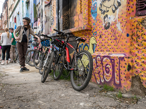 Bogota, Colombia - April 30, 2016: Tourist stands next to bicycles leaning against colorful walls during the cycling trail in Bogota, Amreryka Południe