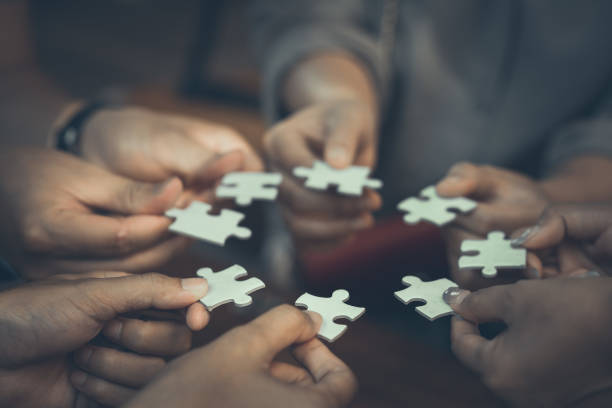 istock Team placing four puzzles jigsaw together for team concept 1408891266
