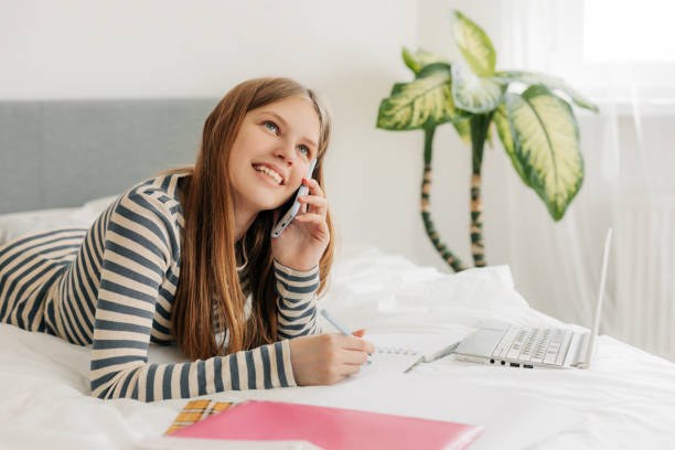 istock A student girl is talking on the phone, discussing homework with classmates. Modern technologies and communications in education 1408893326