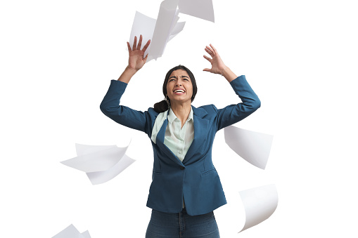 Young Venezuelan businesswoman stressed throwing paperwork. Isolated over white background.