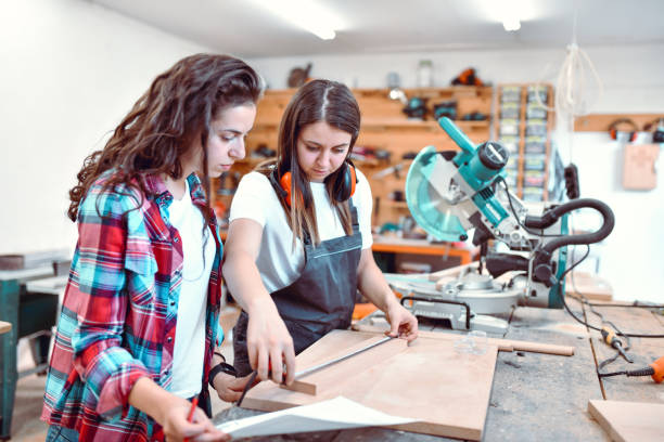 istock Female Wood Worker And Interior Designer Comparing Calculations To Material Length In Workshop 1408893467