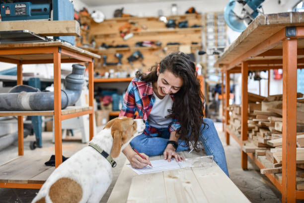 istock Dog Assisting Female Designer In Her Blueprint Drawing 1408893578