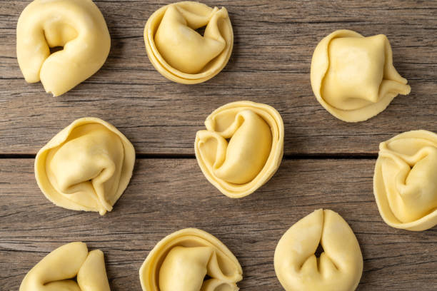 istock Uncooked cappelletti or tortellini over wooden table 1408895053