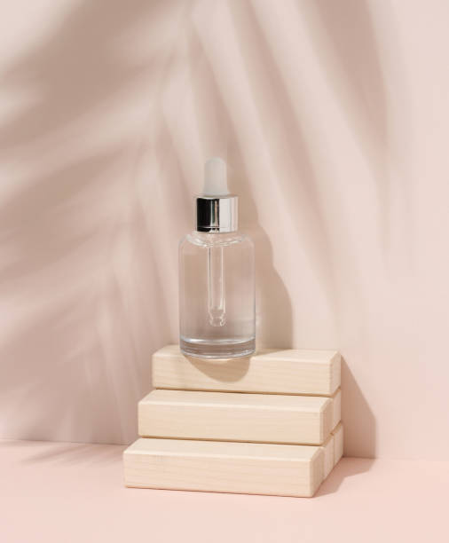 istock White glass bottle with a pipette on beige background. Palm leaf shadow 1408895189