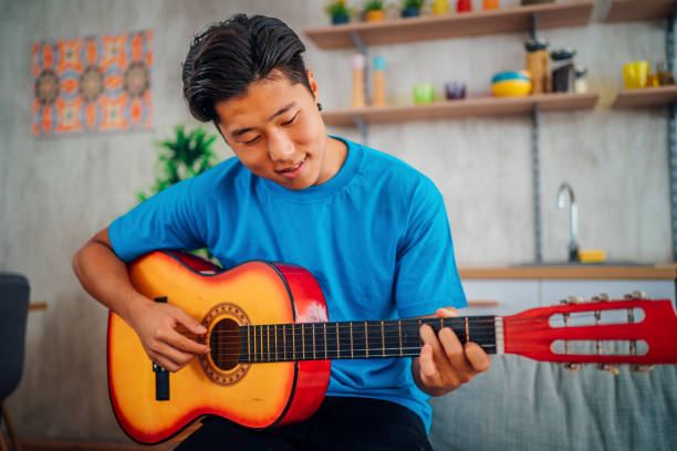istock Man playing acoustic guitar at home 1408895523