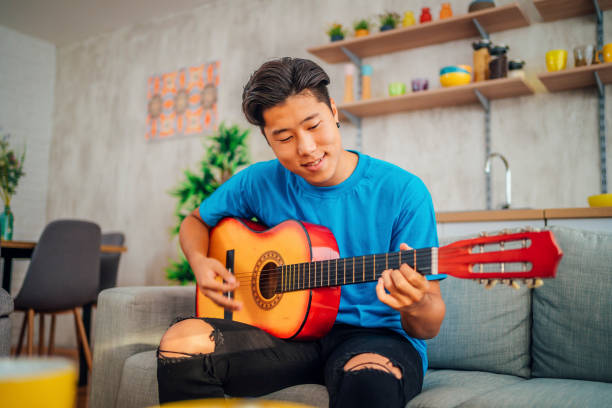 istock Man playing acoustic guitar at home 1408896538