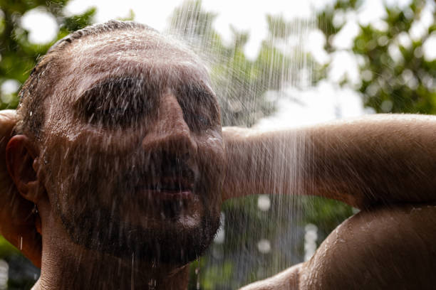 istock White man enjoy outdoor shower, warm look. 1408896717