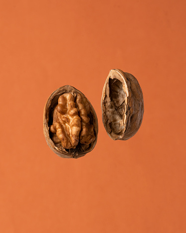 Walnut levitation. Walnuts on a orange background.