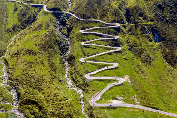 Directly from above view of a winding mountain road with car traffic, Splügen Pass, Graubunden Canton, Swiss Alps.