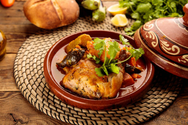 marokański kurczak i warzywa tangine z chlebem podany w naczyniu izolowanym na drewnianym tle widok z boku - tangine zdjęcia i obrazy z banku zdjęć
