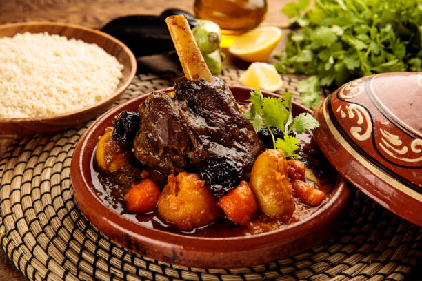 moroccan lamb and vegetables tangine with bread served in a dish isolated on wooden background side view - tangine imagens e fotografias de stock