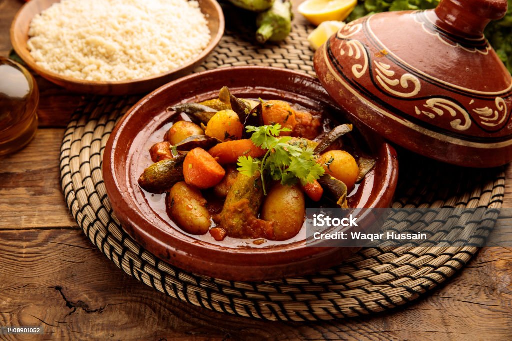 Moroccan tagine with rice served in a dish isolated on wooden background side view Tajine Stock Photo