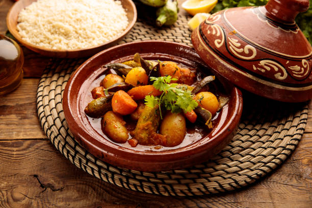 Moroccan tagine with rice served in a dish isolated on wooden background side view stock photo