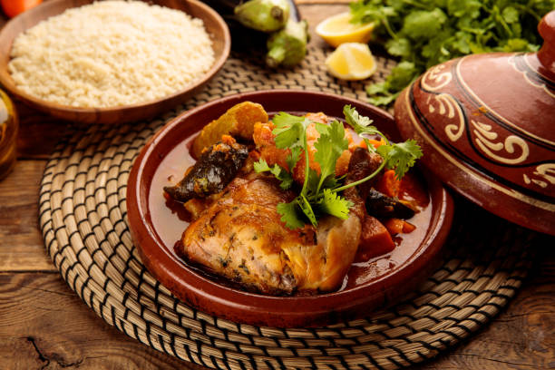marokański kurczak i warzywa tangine z kuskusem i chlebem podawany w naczyniu izolowanym na drewnianym tle widok z boku - tangine zdjęcia i obrazy z banku zdjęć