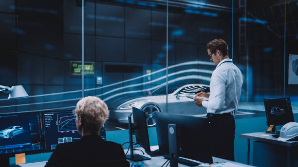 istock Engineering Research Agency Perform Aerodynamic Testing with a Modern Eco-Friendly Electric Sports Car in a Wind Tunnel. Chief Development Officer Works on a Tablet and Changes Testing Options. 1408904511