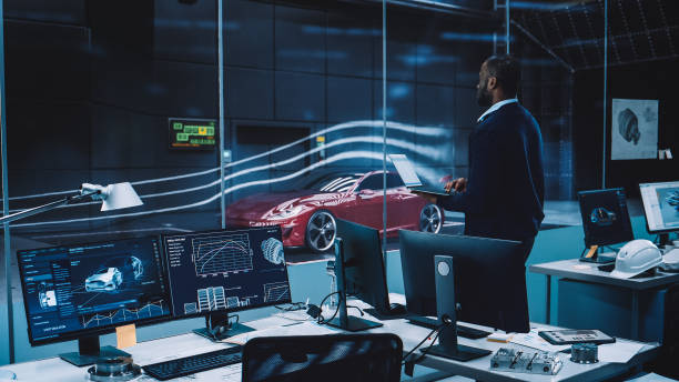 istock Engineering Research Agency Perform Aerodynamic Testing with a Modern Eco-Friendly Electric Sports Car in a Wind Tunnel. Professional Scientist Works on a Laptop Computer and Changes Testing Options. 1408904995
