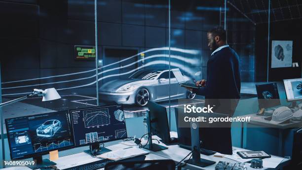 Engineering Research Agency Perform Aerodynamic Testing With A Modern Ecofriendly Electric Sports Car In A Wind Tunnel Professional Scientist Works On A Laptop Computer And Changes Testing Options Stock Photo - Download Image Now